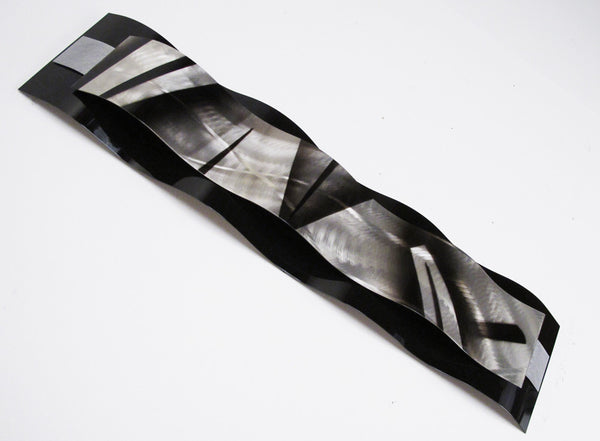 black and silver metal wall sculpture on white background